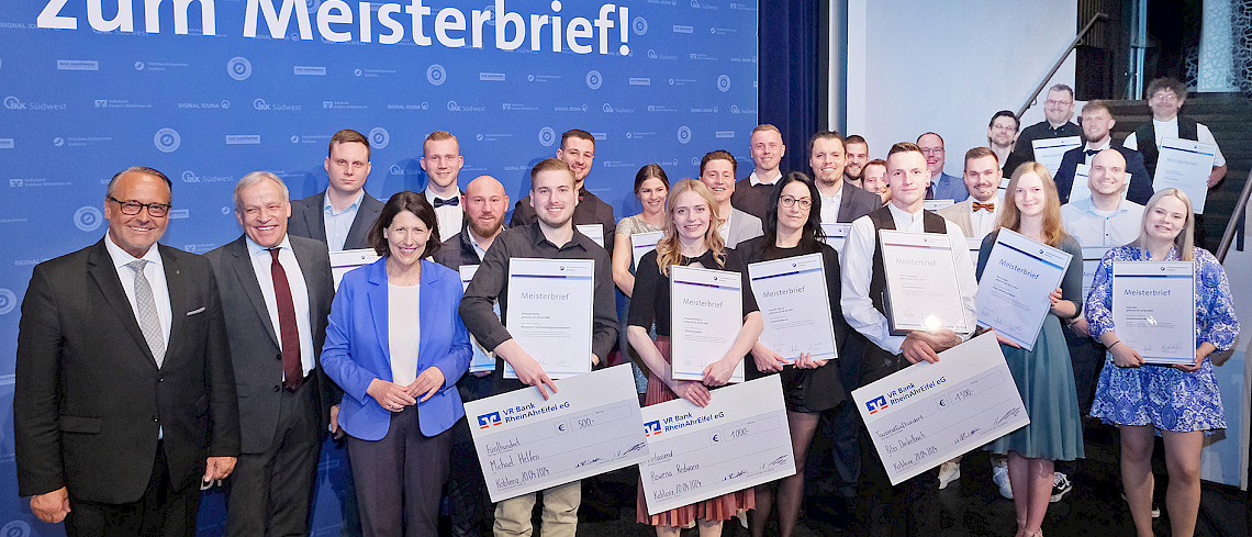 Die 23 Besten ihres Gewerkes erhielten aus Händen von HwK-Hauptgeschäftsführer Ralf Hellrich (vordere Reihe von links), Präsident Kurt Krautscheid und Wirtschaftsministerin Daniela Schmitt auf der Bühne ihre Großen Meisterbriefe.