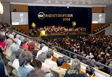 Junge Handwerksmeister mit Gästen bei der Meisterfeier