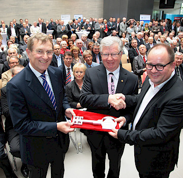 Architekt Thomas Steinhardt übergibt den symbolischen Schlüssel an HwK-Präsident Werner Wittlich und HwK-Hauptgeschäftsführer Alexander Baden