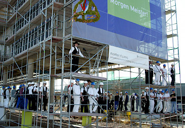 Gäste beim Richtfest auf der Baustelle des Kompetenzzentrums für Gestaltung, Fertigung und Kommunikation