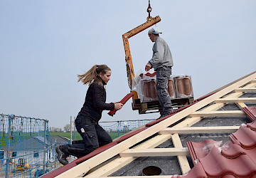 Dachdeckerin beim Decken eines Daches
